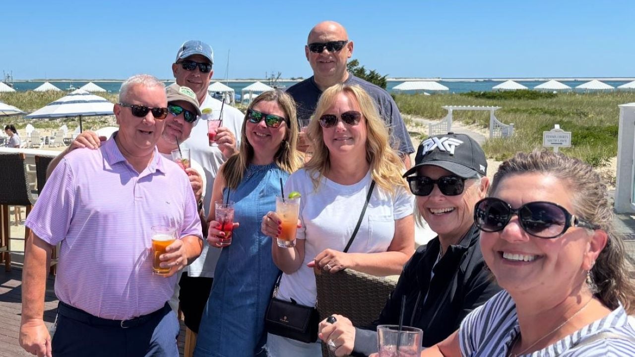 Tour guests with cocktails on the beachside deck at Chatham Bars Inn